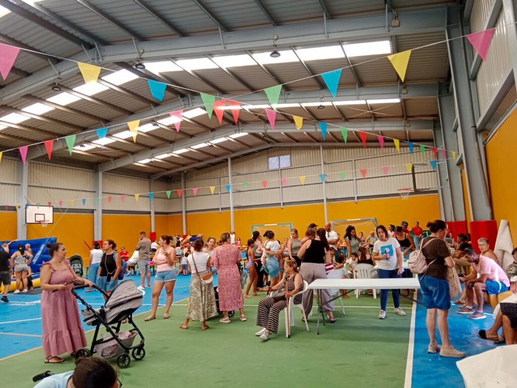 Familias reunidas en el pabellón durante el almuerzo vecinal