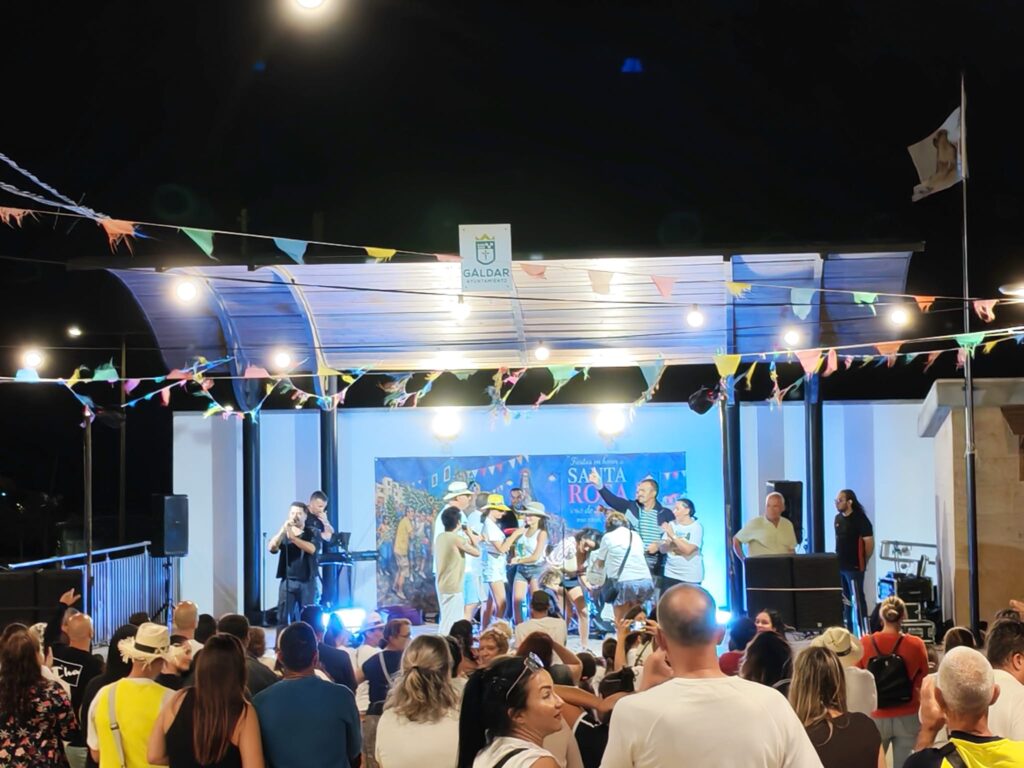 Actuación en el escenario con vecinos bailando